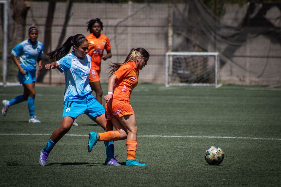 Female soccer players competing intensely on the field during a game.