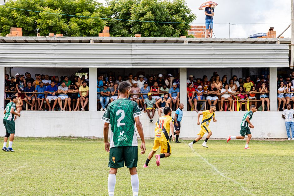 Action shot of an amateur soccer match with a lively audience watching intently.