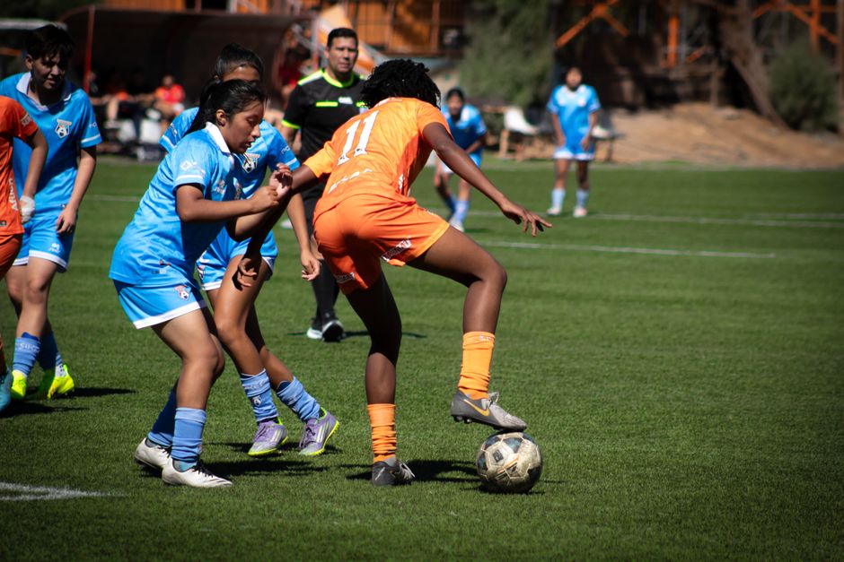 Action shot of a women's soccer match highlighting teamwork and competition.