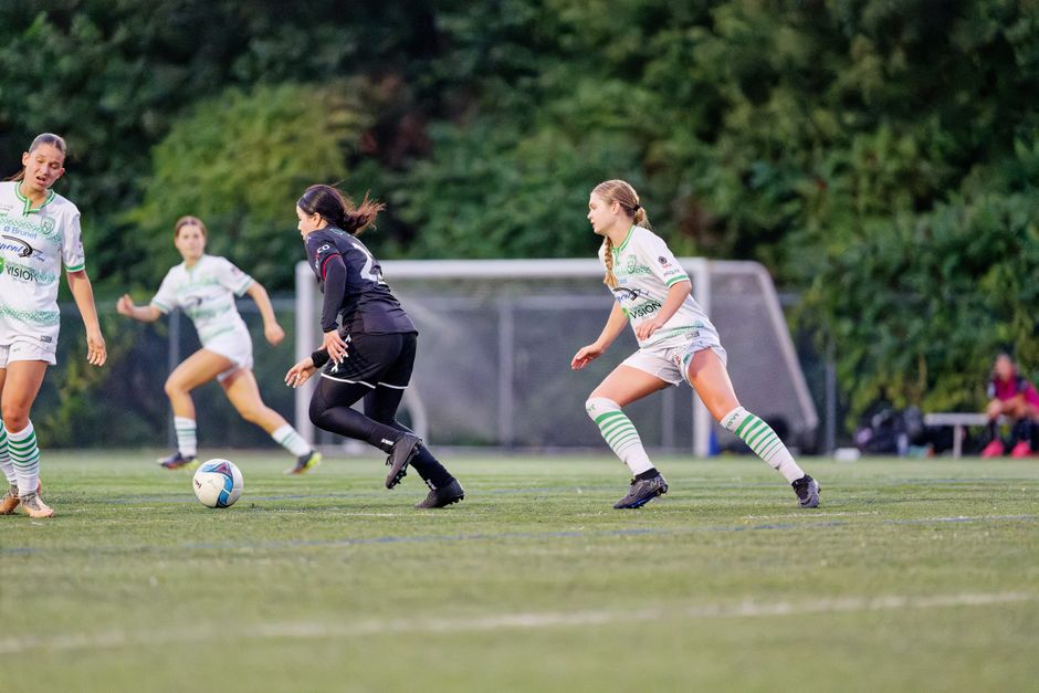 Dynamic capture of female soccer players competing on a green field.