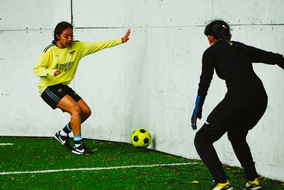 Two female soccer players in action during a match in Mexico City, demonstrating skill and teamwork.