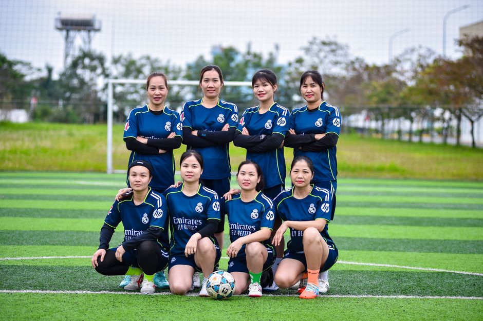 A women's soccer team posing proudly on an outdoor field in Hà Nội, Vietnam.