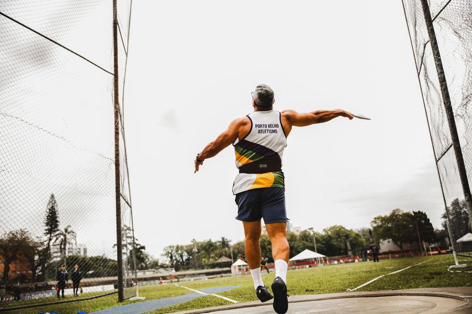 Dynamic shot of an athlete throwing a discus outdoors, showcasing athleticism and motion.